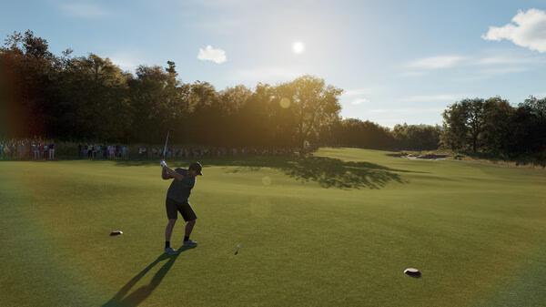 A golfer swings on a sunny course in PGA TOUR 2K25. Screenshot shows lush greens and a crowd in the background.