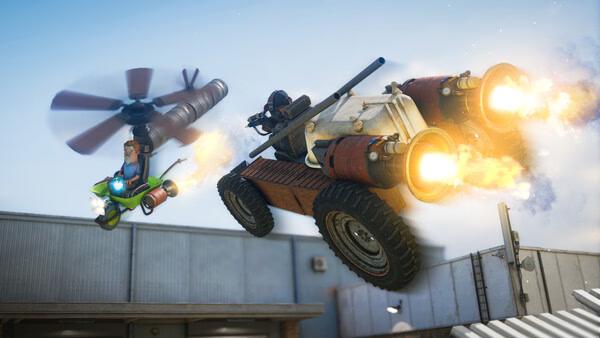 s&box screenshot: A flying machine and a rocket-powered vehicle race above rooftops, leaving fiery exhaust trails in the sky.