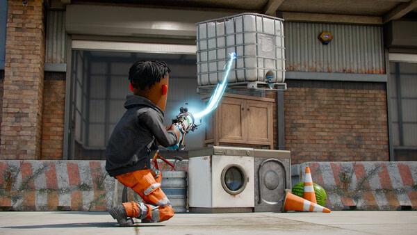 A s&box screenshot showing a character using a glowing energy beam to interact with stacked objects outside a building.