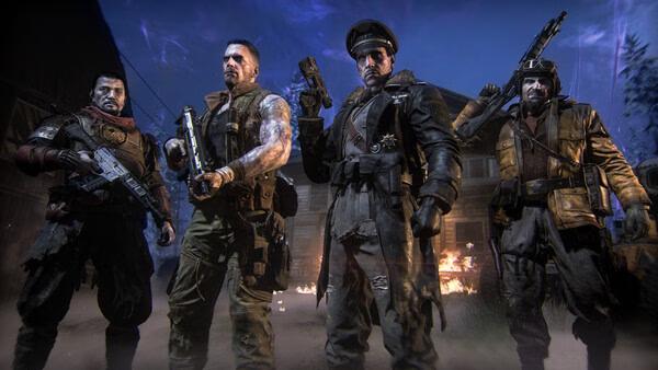 Screenshot from Call of Duty: Black Ops 7 showing four soldiers in tactical gear standing in front of a burning building.