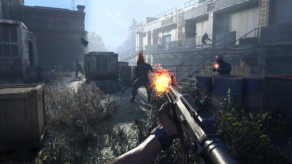 A Dying Light: The Beast screenshot showing intense combat, with a player firing at enemies in an industrial outdoor setting.