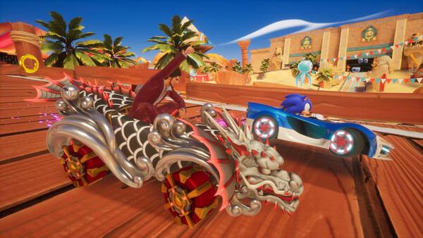 Screenshot of Sonic Racing: CrossWorlds showing Sonic in a blue car racing against a dragon-themed vehicle on a sunny track.