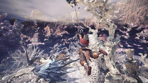 Monster Hunter: World screenshot featuring a hunter mid-air, aiming a weapon at a dragon-like creature in a rugged landscape.