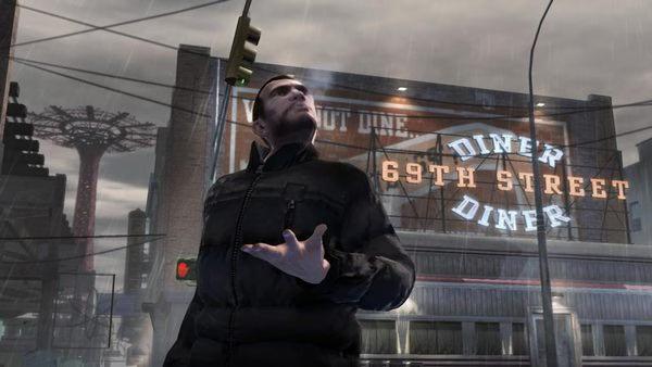 Grand Theft Auto IV screenshot: A character stands in front of a diner sign during a rainy day, gesturing with one hand.
