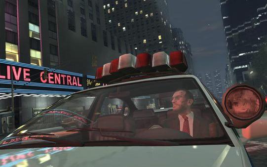 A Grand Theft Auto IV screenshot showing a police car driving through a city street at night, with buildings and neon lights in view.