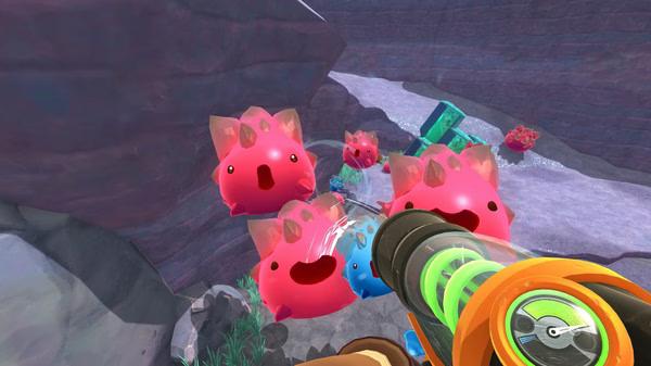Screenshot from Slime Rancher showing player aiming a vacuum at pink slimes in a rocky canyon environment.