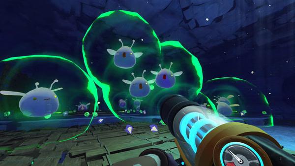 Screenshot from Slime Rancher showing a player using a vacpack to capture glowing, green phosphor slimes in a cave.