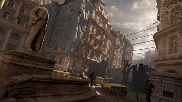 Half-Life: Alyx screenshot showing a detailed city street with a statue, abandoned vehicles, and armed characters exploring.