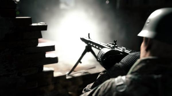 Hell Let Loose screenshot: A soldier in a helmet fires a machine gun from behind a brick wall, light illuminating the scene.
