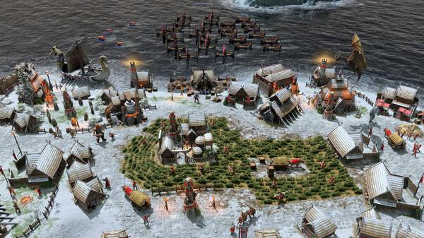 Screenshot from Age of Mythology: Retold showing a snowy village with buildings, units, and ships near the water's edge.