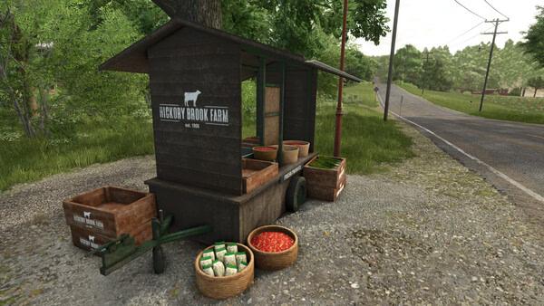 Farming Simulator 25 screenshot: A rustic produce stall labeled "Hickory Brook Farm" with crates of vegetables by a country road.