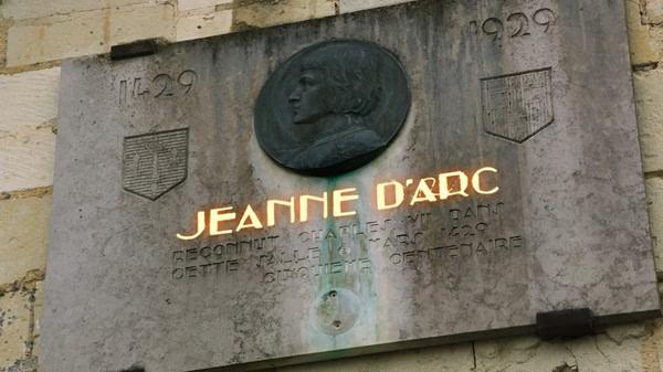 Plaque of Jeanne d'Arc in Age of Empires IV screenshot, featuring engraved text and dates on a stone wall.