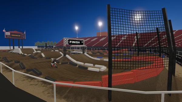 MX Bikes screenshot of a motocross rider racing on a dirt track in a stadium under bright lights near the finish line.