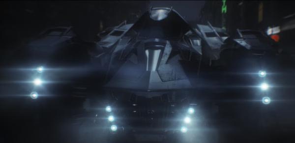 Batman: Arkham Knight screenshot showing the Batmobile illuminated by bright lights in a dark city setting.