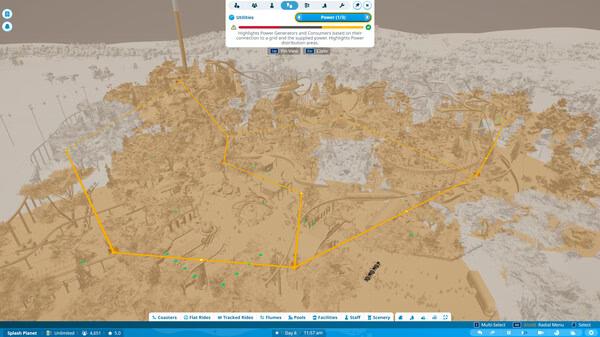 Screenshot of Planet Coaster 2 showing a theme park layout in blueprint mode with highlighted power grid areas and various park elements.
