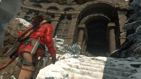 A screenshot from Rise of the Tomb Raider shows the protagonist, Lara Croft, approaching a snow-covered ancient ruin.