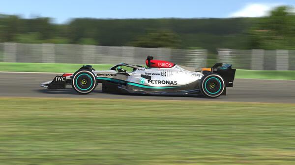 iRacing screenshot showing a Mercedes-AMG Formula 1 car speeding on a sunny racetrack with a blurred forest backdrop.