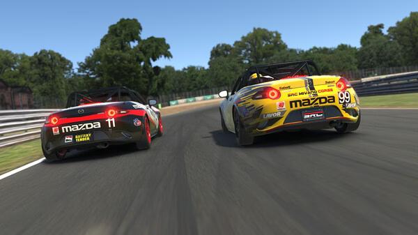 Mazda cars race side by side on a curvy track in this iRacing screenshot, surrounded by trees and barriers.