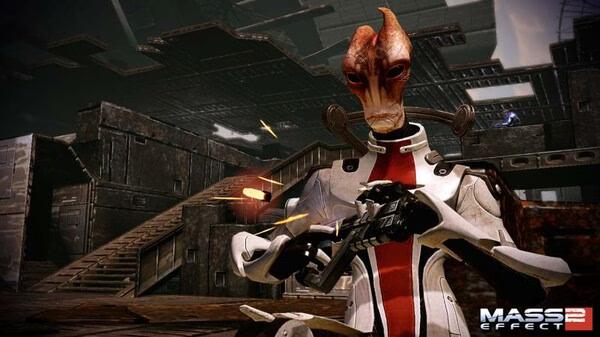 Screenshot from Mass Effect 2 showing a Salarian character in combat gear, firing a weapon in an industrial setting.
