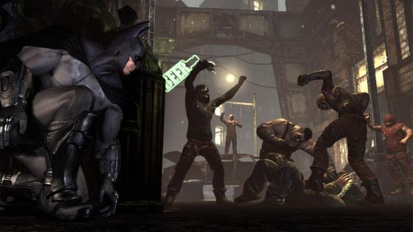 Batman: Arkham City screenshot of Batman crouching near a fight scene with thugs in a dimly lit, urban alley.