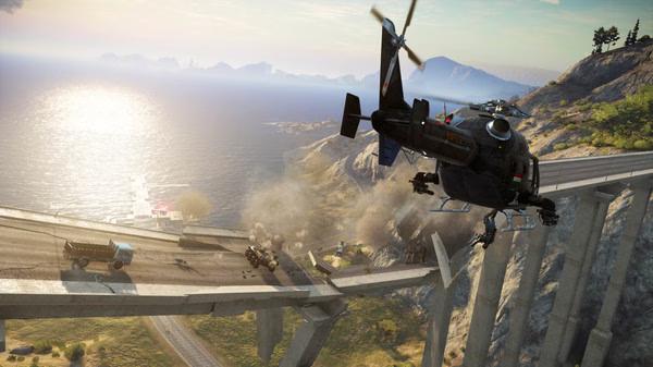A helicopter swoops over a destroyed bridge in this Just Cause 3 screenshot, with smoke and vehicles scattered below.