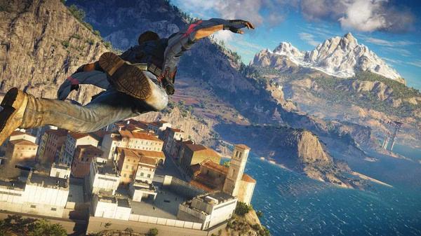 Just Cause 3 screenshot: A character glides through the air above a coastal town with mountains and ocean in the background.