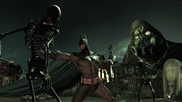 Batman: Arkham Asylum screenshot: Batman battles skeleton-like enemies in a dark graveyard as Scarecrow looms in the background.
