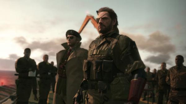 Screenshot from Metal Gear Solid V: The Phantom Pain showing a group of soldiers standing together under a cloudy sky.