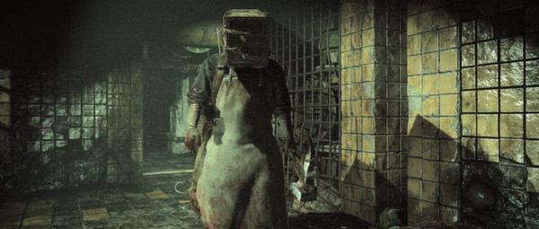 Screenshot from The Evil Within showing a menacing figure in a bloodstained apron and a metal box helmet, walking through a dim corridor.