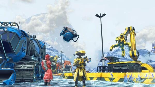 No Man's Sky screenshot: Two characters stand on icy terrain, surrounded by machinery and a flying drone under a cloudy sky.
