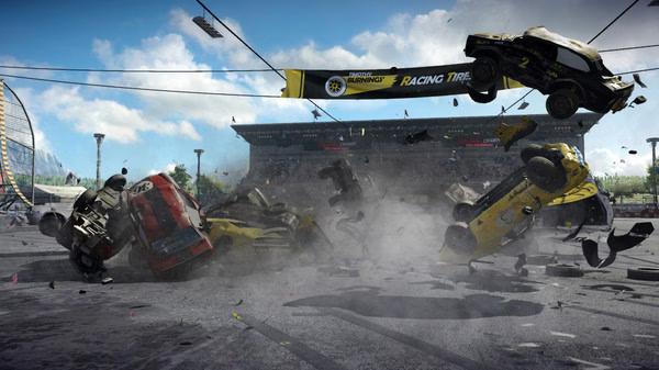 Wreckfest screenshot: multiple cars collide in a chaotic crash on a racetrack, with debris scattered and dust rising.