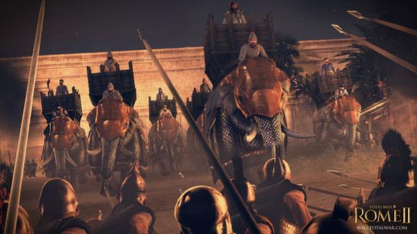 Screenshot from Total War: Rome II - Emperor Edition showing soldiers facing a charge of armored war elephants near a large stone wall.