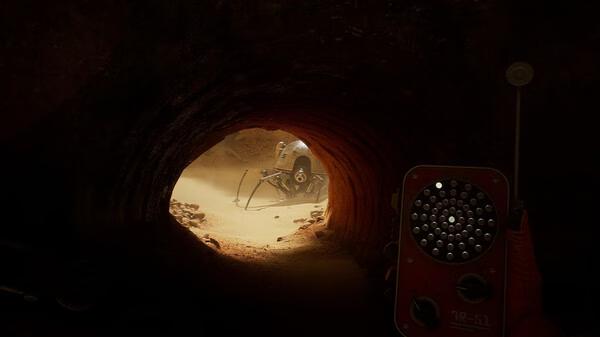 Screenshot from "The Invincible" showing a rover in a desert tunnel, with a hand-held device visible in the foreground.