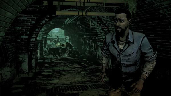 A screenshot from The Walking Dead: The Telltale Definitive Series shows a character walking through a dark, eerie tunnel.