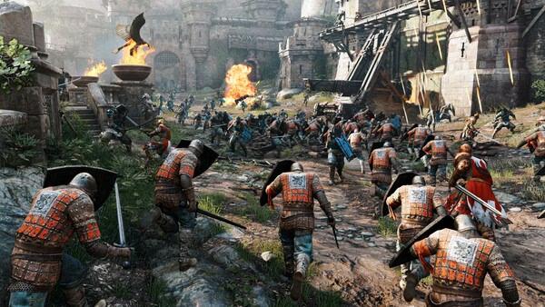 For Honor screenshot: Intense medieval battle scene with armored warriors clashing near a castle, flames and chaos surrounding them.