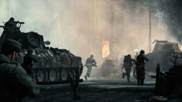 Call to Arms - Gates of Hell: Ostfront screenshot featuring soldiers advancing near armored vehicles in a smoky battlefield.