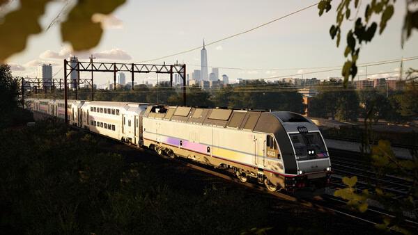 Train Sim World 6 screenshot: A modern passenger train travels along tracks with a city skyline visible in the background.
