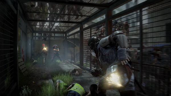 World War Z screenshot: Players battle zombies in a fenced corridor, with one character firing a weapon amidst the chaos.