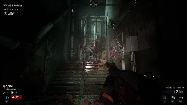 A "Killing Floor 3" screenshot showing a player aiming at grotesque creatures in a dimly lit, blood-splattered stairway.