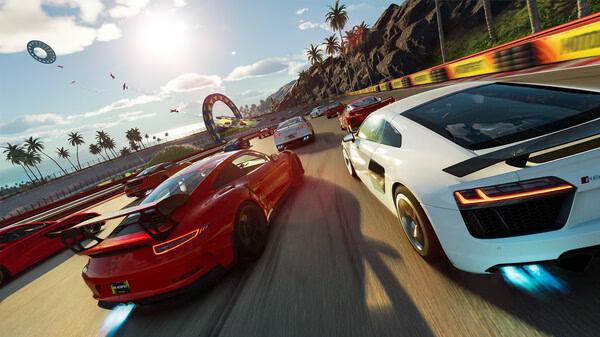 A screenshot from The Crew Motorfest showing sports cars racing on a sunny coastal track with palm trees and a loop in the distance.