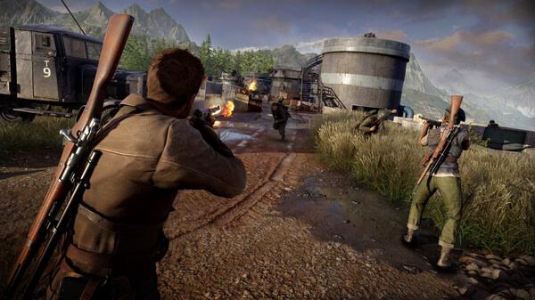 Screenshot of Sniper Elite: Resistance shows armed soldiers sneaking around industrial tanks in a mountainous, forested area.
