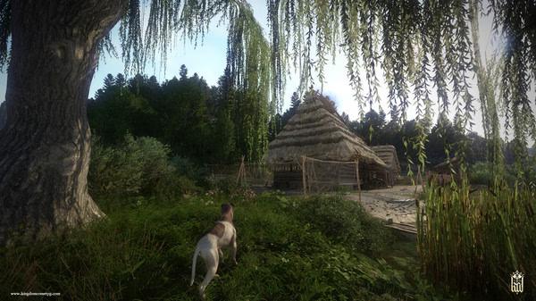 A dog stands near a willow tree, gazing at a thatched hut in a lush landscape. Kingdom Come: Deliverance screenshot.