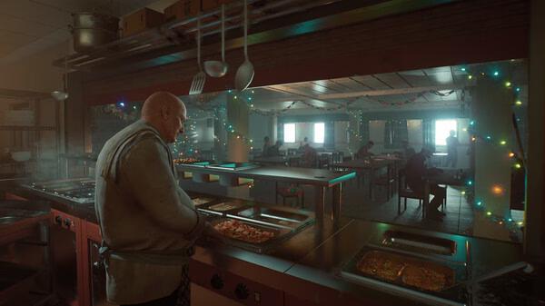 Screenshot from 'Still Wakes the Deep' showing a man serving food in a festive, decorated cafeteria setting.