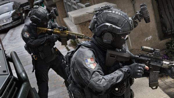 Two armed soldiers in tactical gear patrol an urban street in this Call of Duty®: Modern Warfare® 4 screenshot.