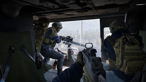 WARDOGS screenshot: Two armed soldiers inside a helicopter aiming weapons at a cityscape visible through the open door.