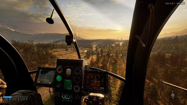 A WARDOGS screenshot showing a helicopter cockpit view flying over a scenic landscape at sunset with detailed controls visible.