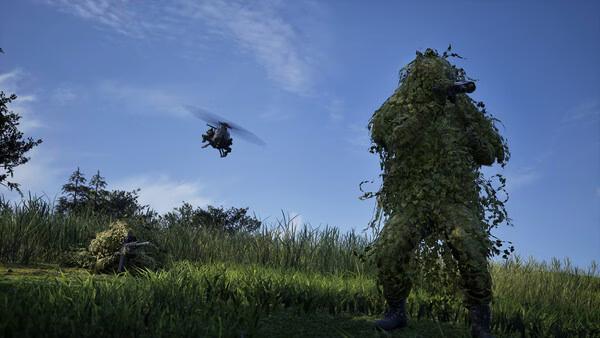 A WARDOGS screenshot showing a camouflaged soldier aiming a weapon, with a helicopter hovering in the blue sky above grassy terrain.