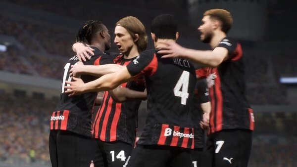A group of soccer players wearing black and red jerseys celebrate on the field in this eFootball™ game screenshot.