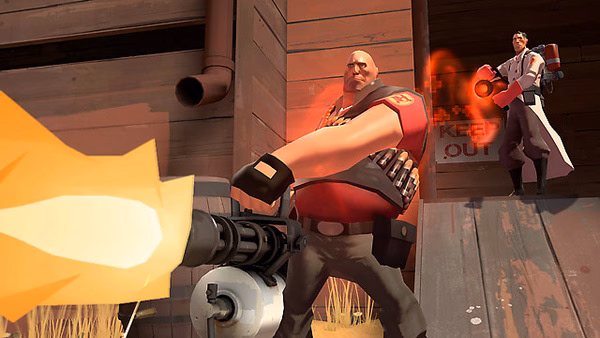 Team Fortress 2 screenshot showing a Heavy firing a minigun, with a Medic behind him using a healing beam near a wooden structure.