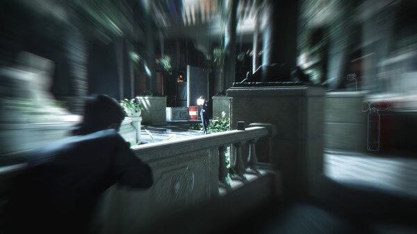 Screenshot from 007 First Light showing a character in stealth mode, crouching behind a stone railing in a dimly lit area.